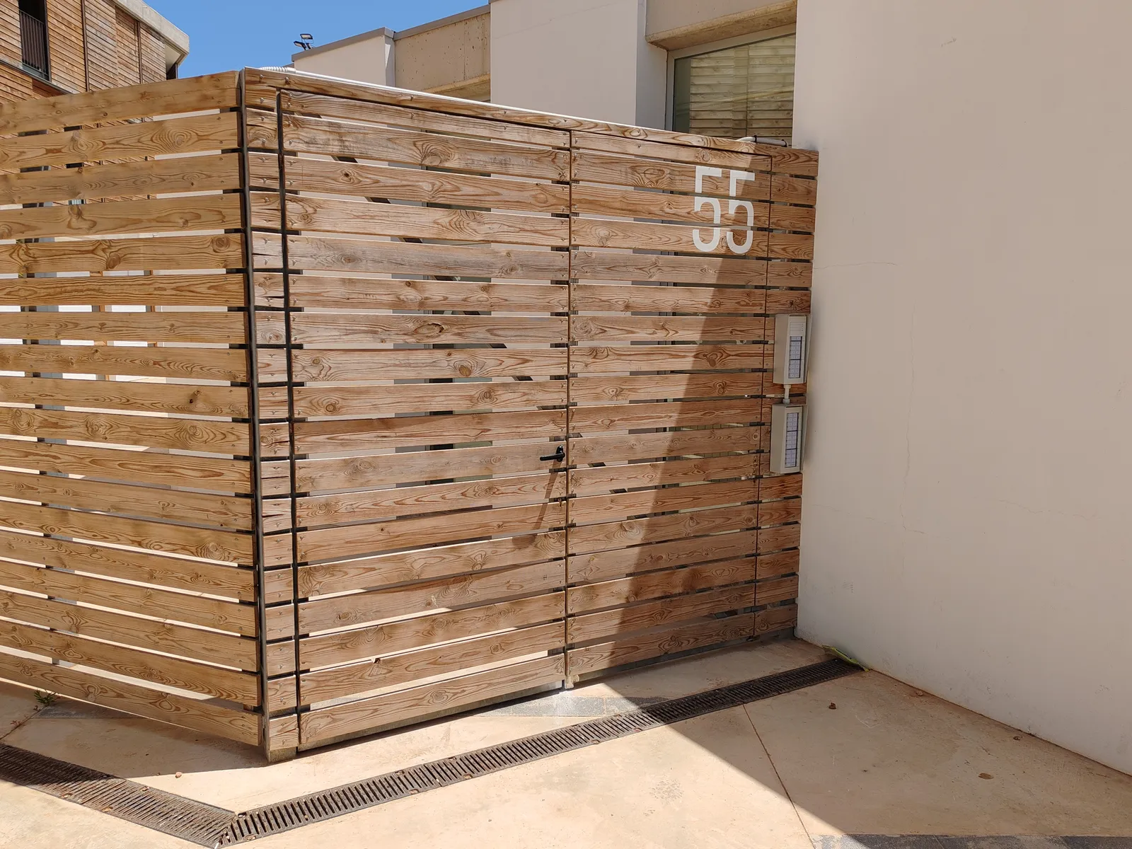 Reparacion y modificacion de puerta de estructura galvanizada con recubrimiento de madera en Mahon Menorca, edificio del Ibavi. - imagen 2