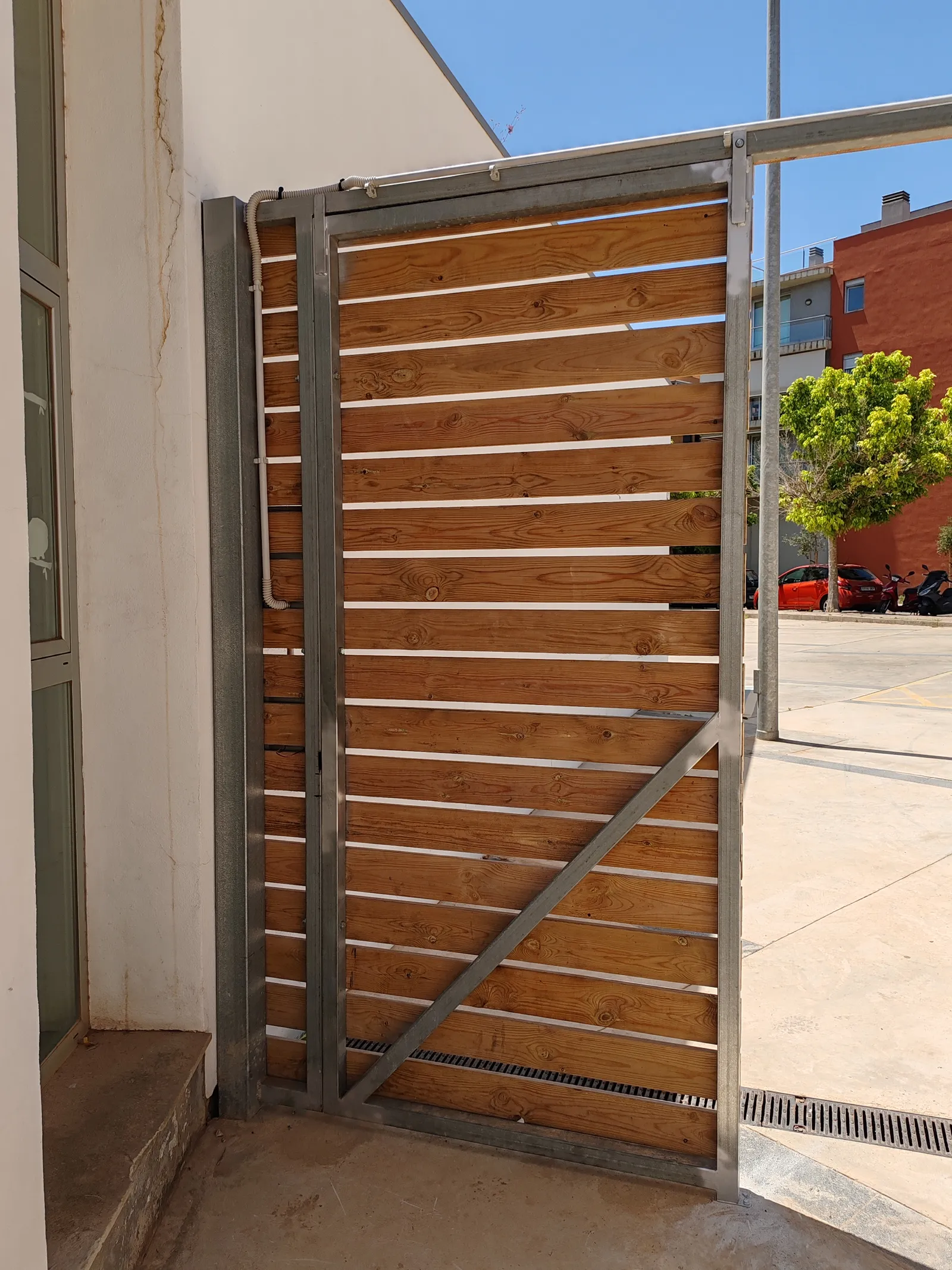 Reparacion y modificacion de puerta de estructura galvanizada con recubrimiento de madera en Mahon Menorca, edificio del Ibavi. - imagen 3
