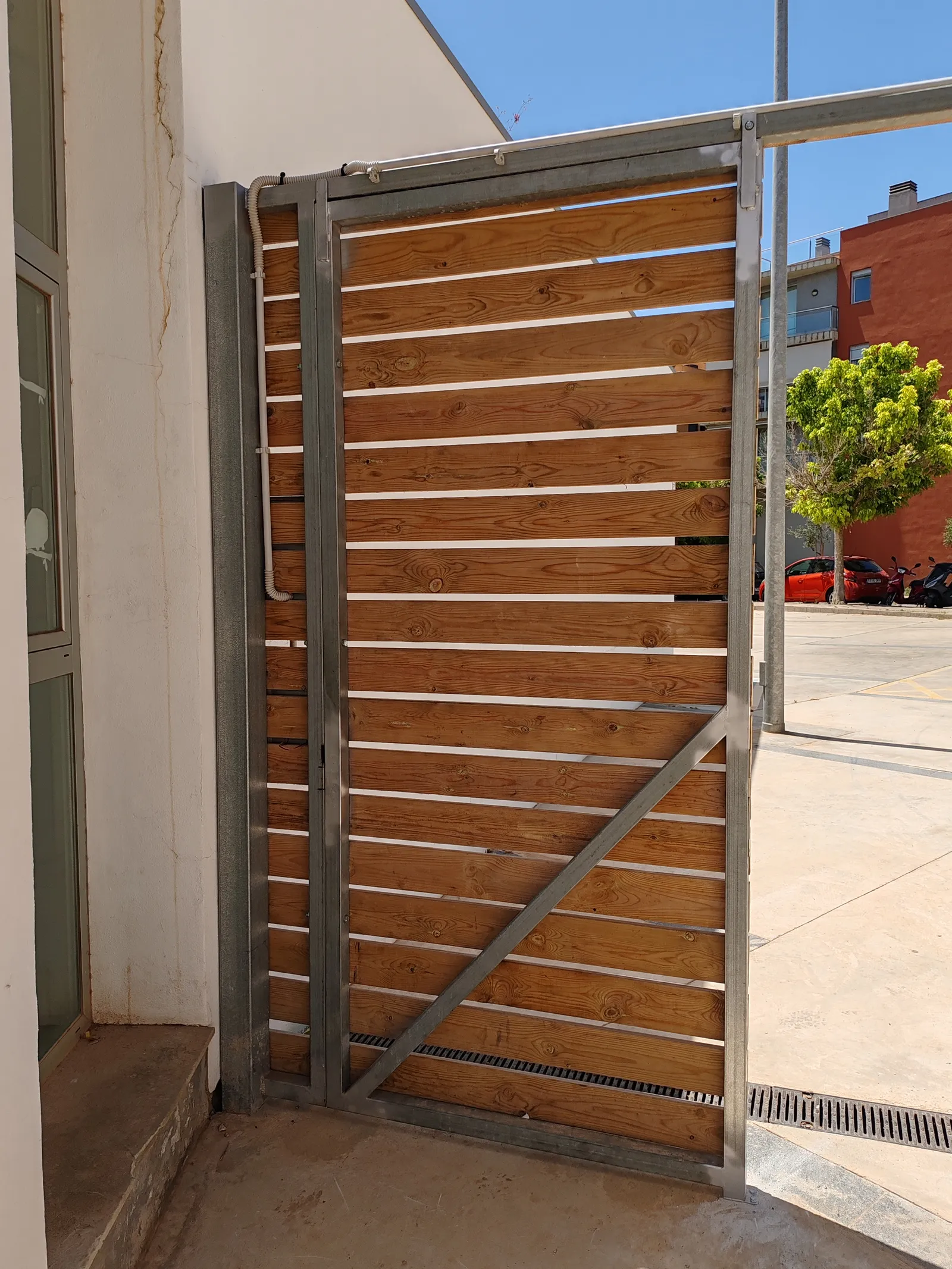 Reparacion y modificacion de puerta de estructura galvanizada con recubrimiento de madera en Mahon Menorca, edificio del Ibavi. - imagen 4