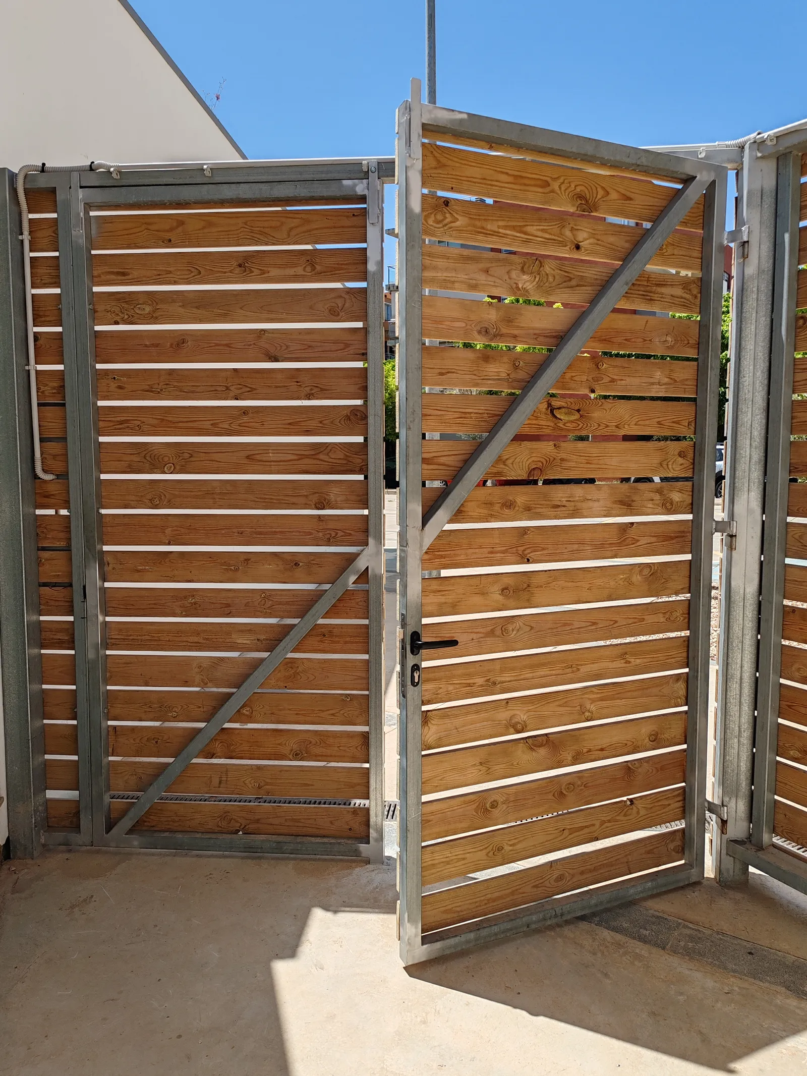 Reparacion y modificacion de puerta de estructura galvanizada con recubrimiento de madera en Mahon Menorca, edificio del Ibavi. - imagen 6